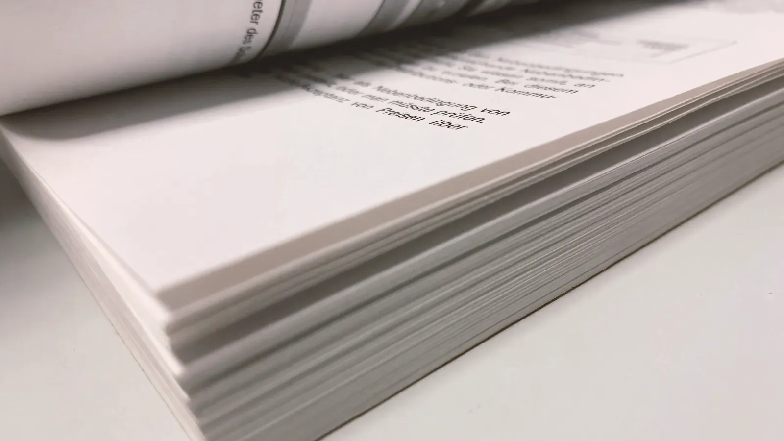 Manuscript pages stacked and lit from one side.